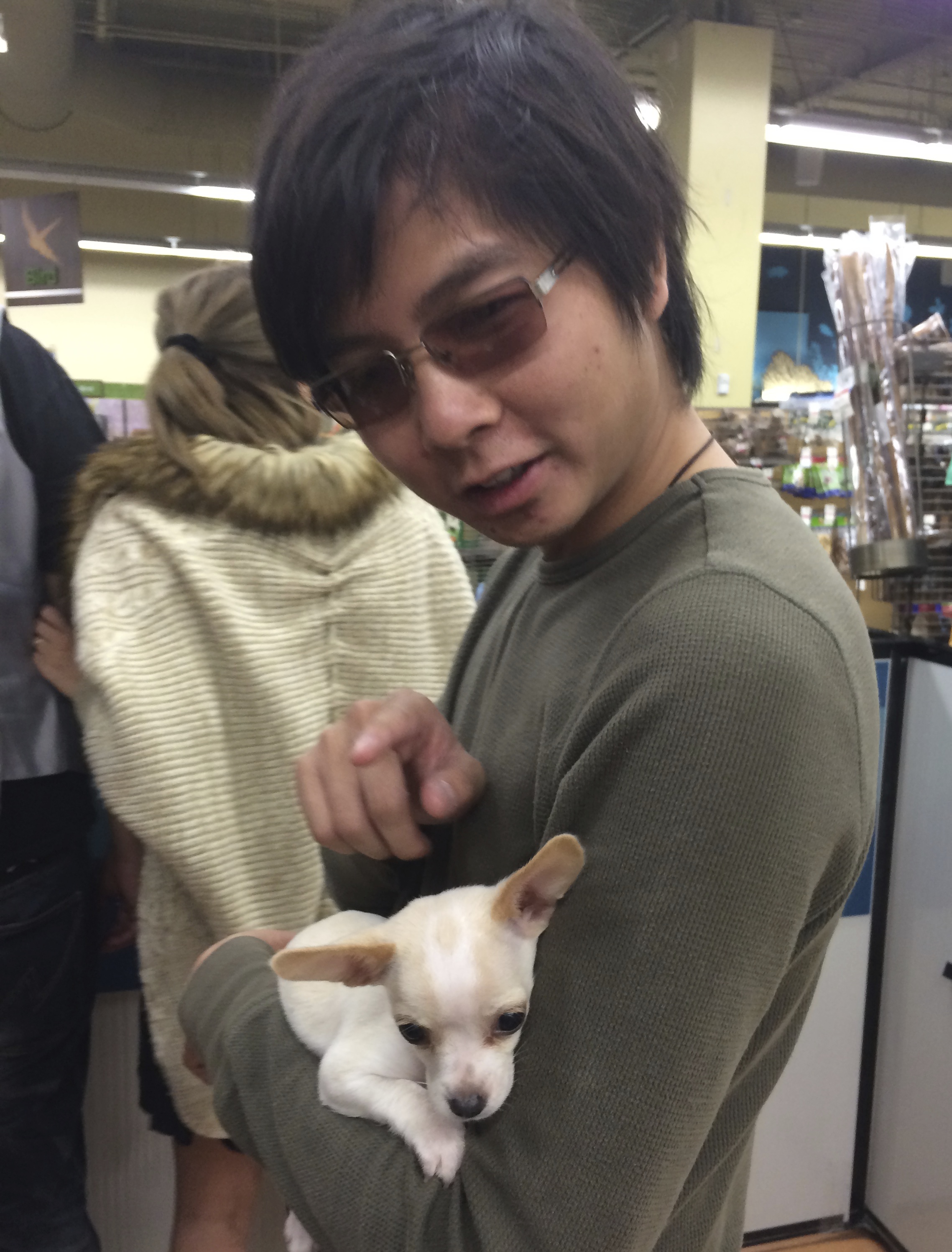 Man Holding White Chihuahua Puppy