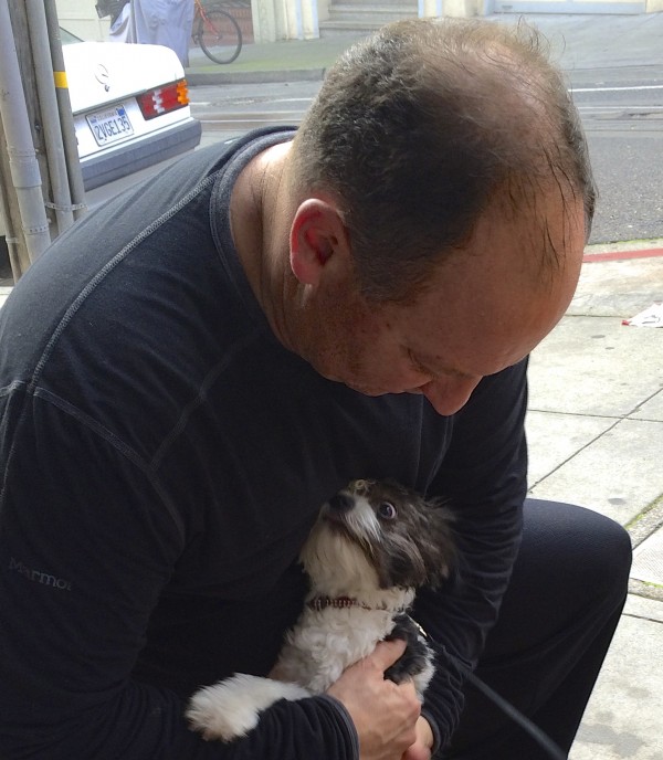 Man Hugging Black And White Maltese Poodle Mix Puppy