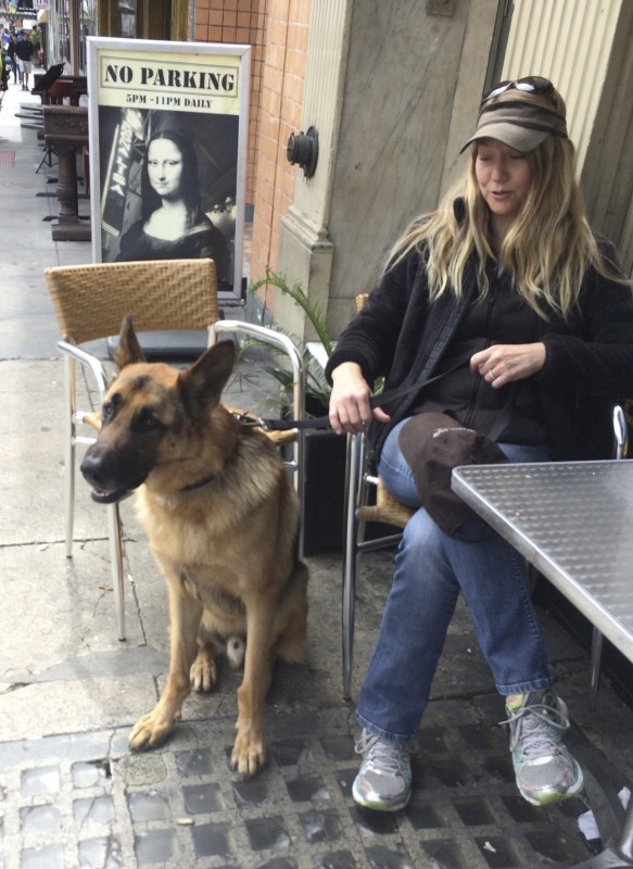 Woman Sitting With German Shepherd Who Is Pulling On His Leash
