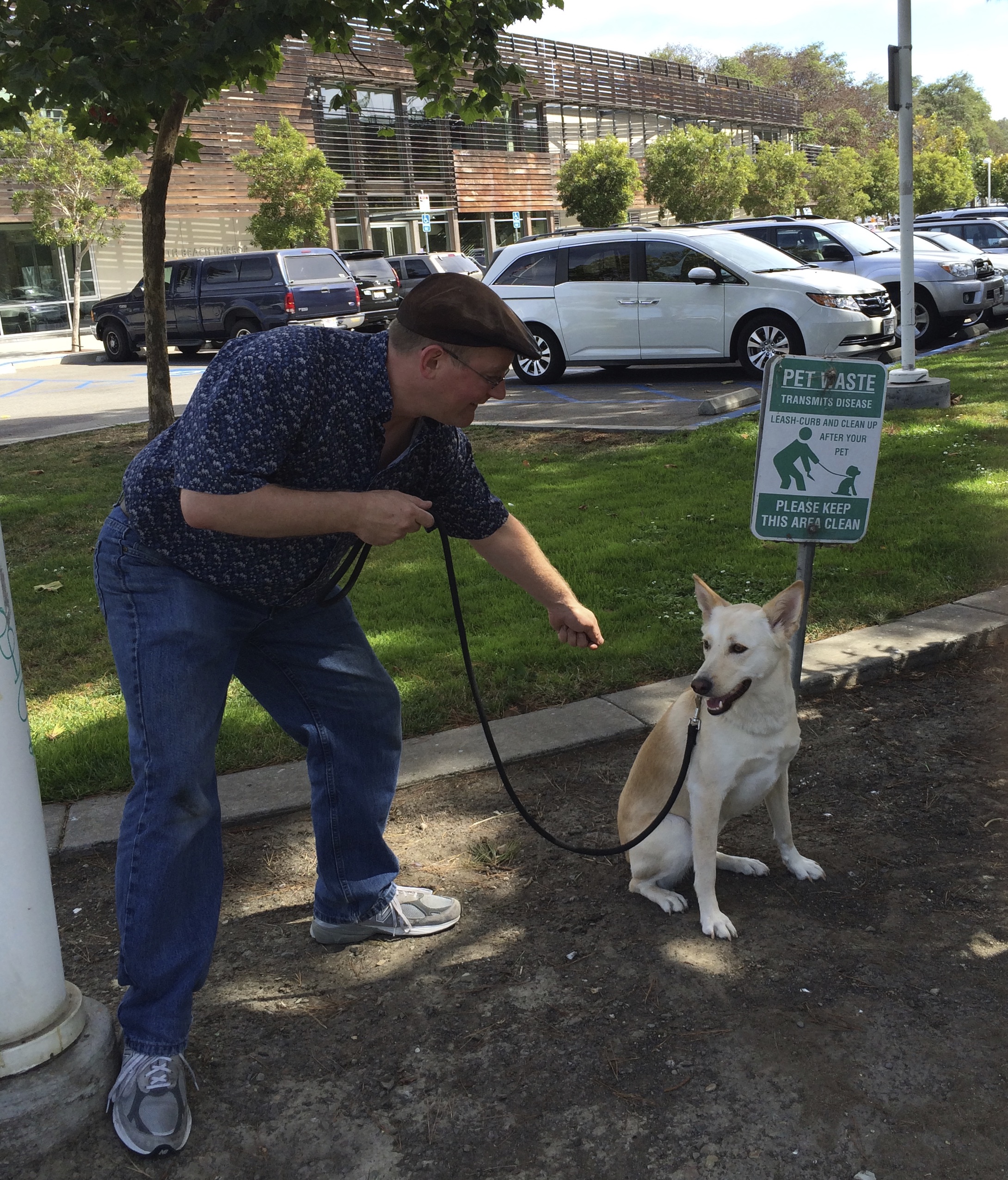 Picture of Man Pointing At Dog Next To Sign With Picture Of Man Pointing At Dog