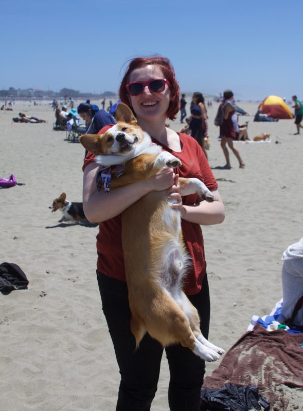 Woman Holding Red And White Pembroke Welsh Corgi In Her Arms