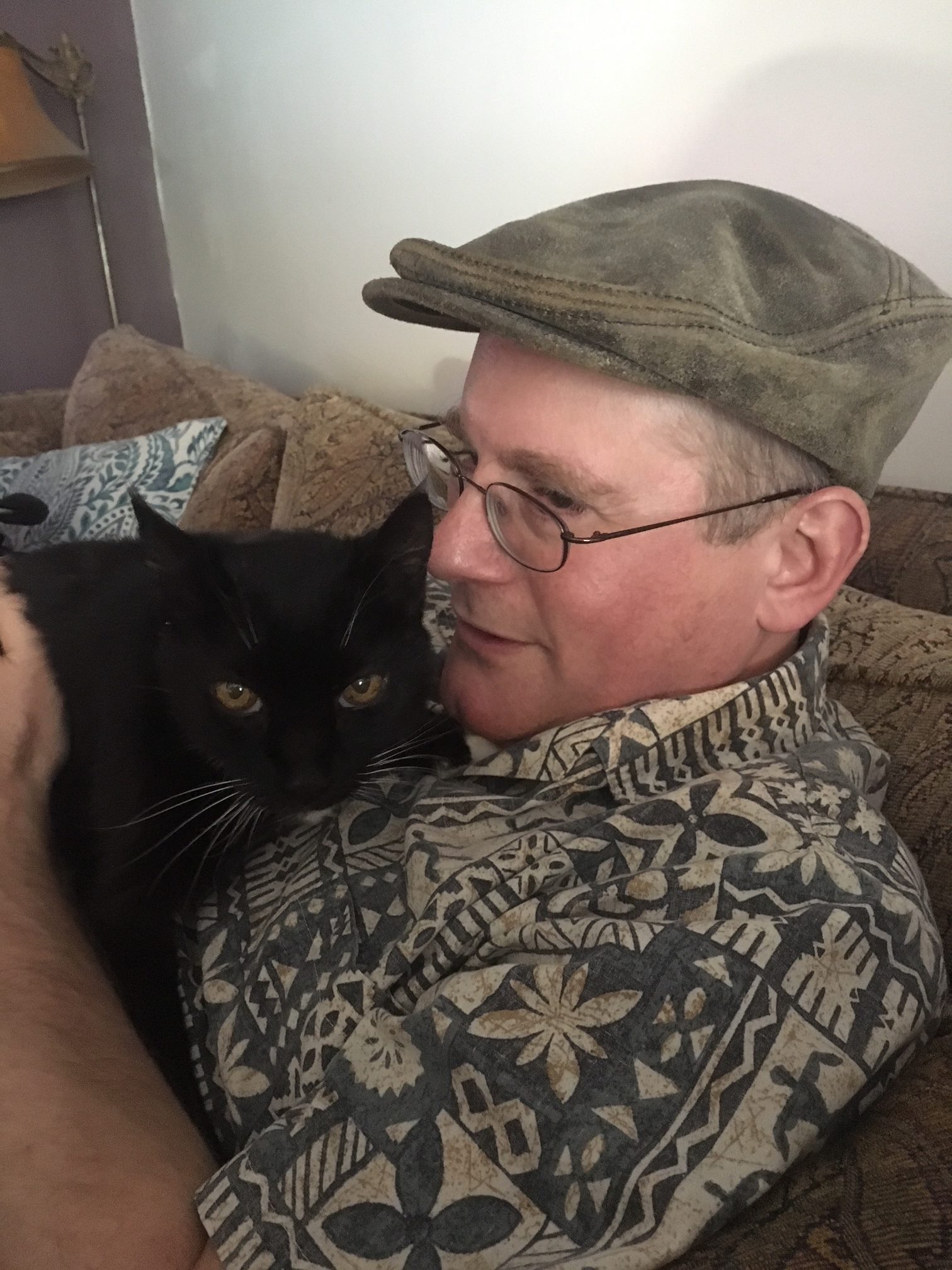 Man Cuddling Tuxedo Cat On His Chest