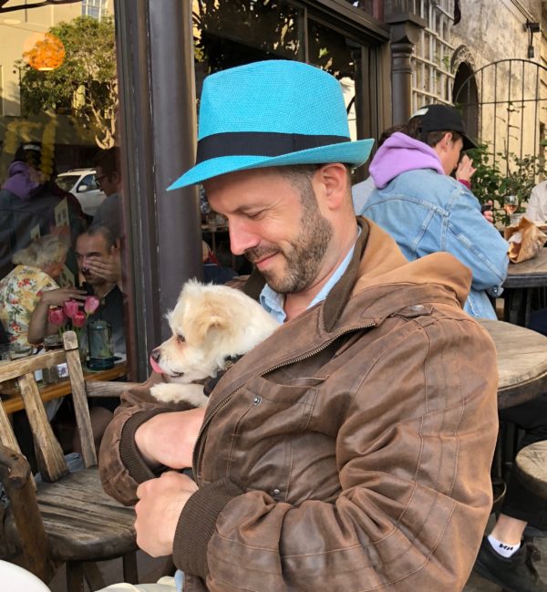 Man With Chihuahua Terrier Mix Cuddled In His Bomber Jacket