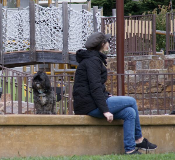 Tibetan Terrier And Woman Sitting On Wall