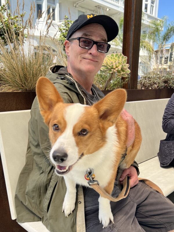 Man Holding Very Curious And Eager Red Pembroke Welsh Corgi