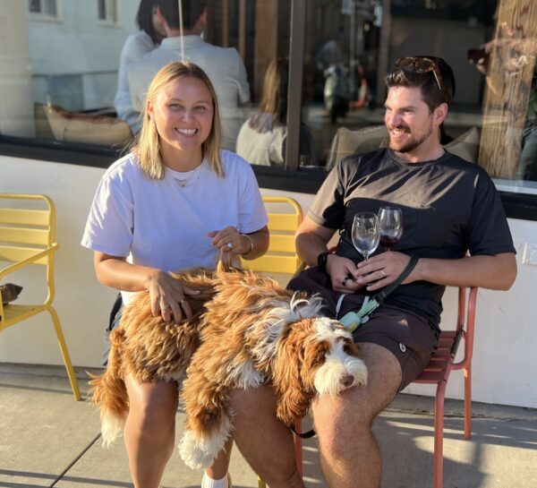 Man And Woman With Australian Labradoodle Puppy Sprawled Across Their Laps